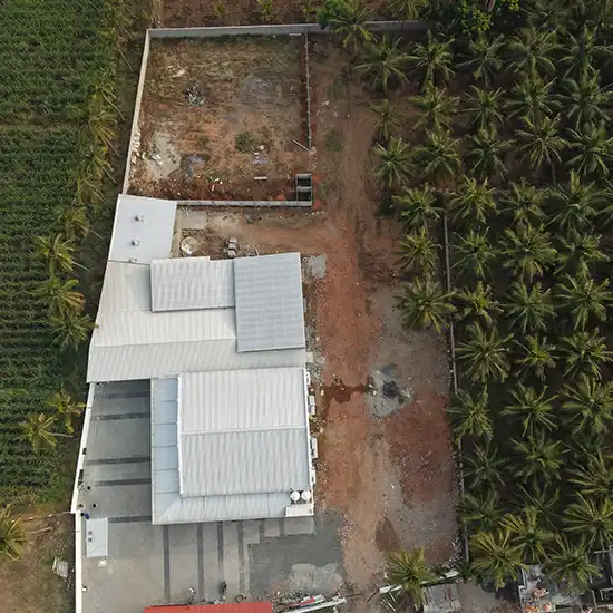 Aerial drone view showcasing the full scale, layout, and surrounding area of a spacious event mahal